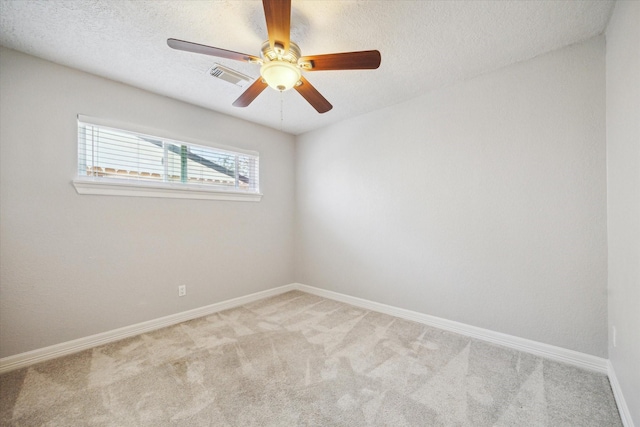 carpeted empty room featuring baseboards, a textured ceiling, and a ceiling fan