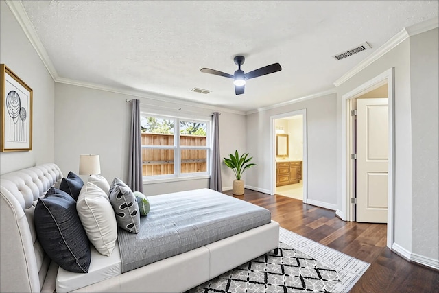 bedroom with dark wood-style floors, baseboards, ensuite bath, crown molding, and a ceiling fan