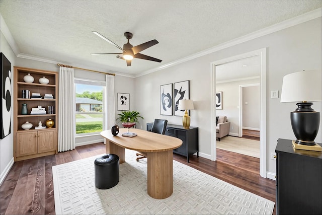 office space featuring a ceiling fan, wood-type flooring, a textured ceiling, ornamental molding, and baseboards