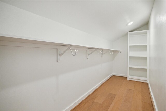 spacious closet featuring light wood-style floors and lofted ceiling