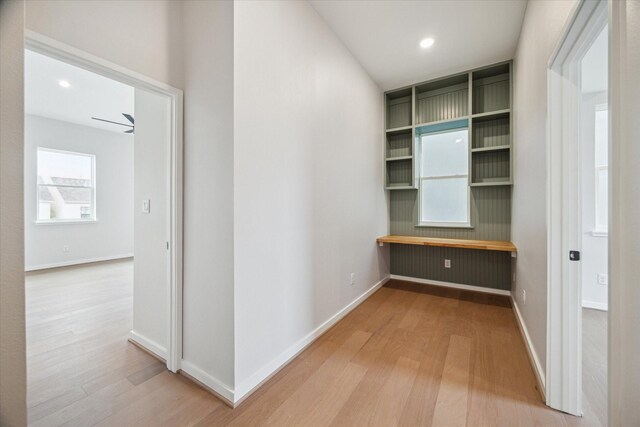 hallway with baseboards, wood finished floors, and recessed lighting
