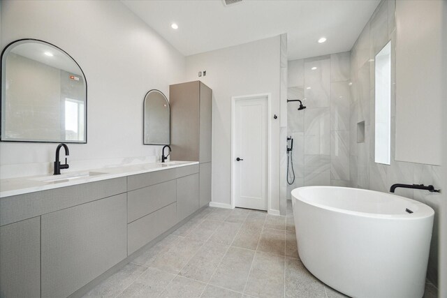 full bathroom featuring tile patterned floors, a sink, double vanity, a freestanding tub, and a walk in shower