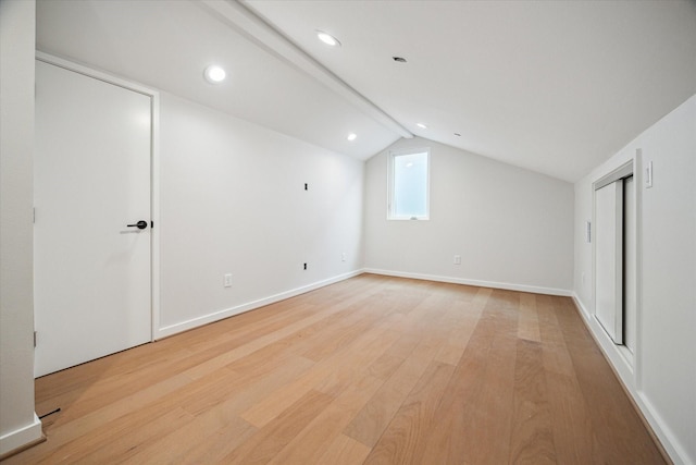 additional living space featuring baseboards, vaulted ceiling, light wood-style flooring, and recessed lighting