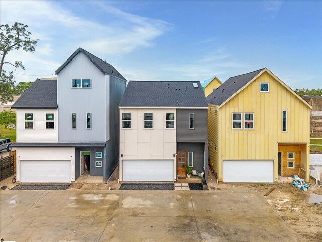 view of front of home with an attached garage, a shingled roof, board and batten siding, and concrete driveway