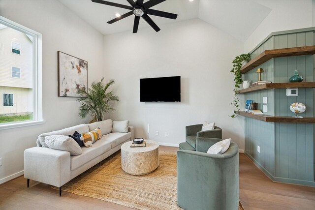 living room featuring vaulted ceiling, wood finished floors, a ceiling fan, and baseboards