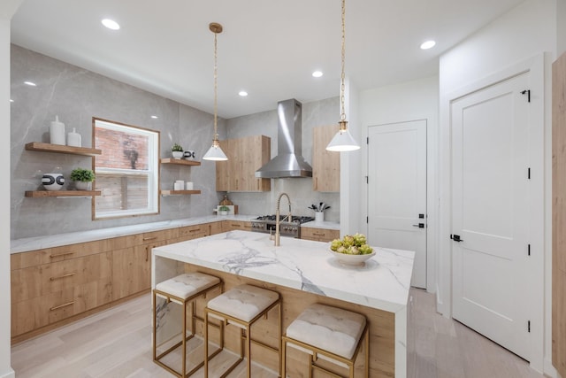 kitchen with open shelves, modern cabinets, light wood-style floors, and wall chimney range hood