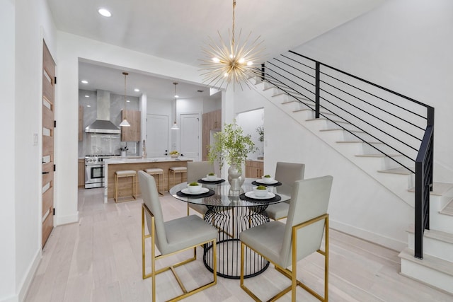dining room featuring baseboards, recessed lighting, light wood-style floors, a notable chandelier, and stairway
