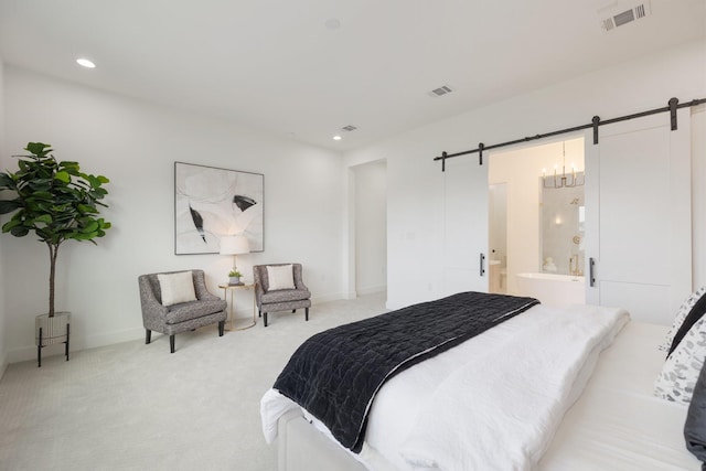 bedroom featuring light carpet, visible vents, and a barn door