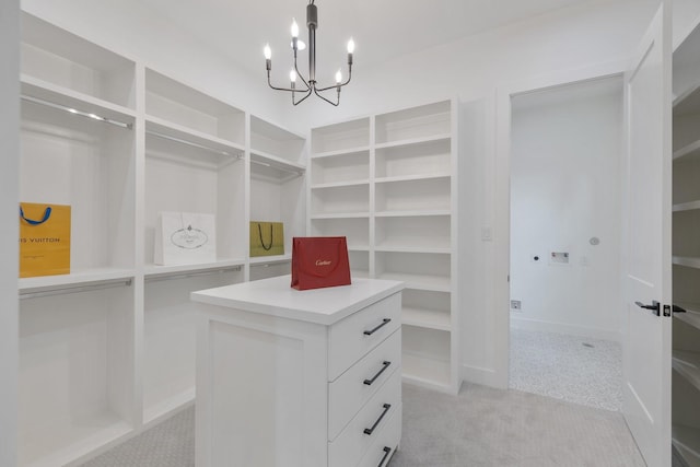 spacious closet featuring light colored carpet and an inviting chandelier