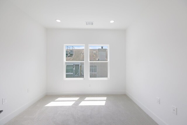 spare room with recessed lighting, baseboards, visible vents, and carpet