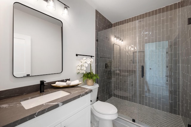 full bathroom with a shower stall, toilet, and vanity