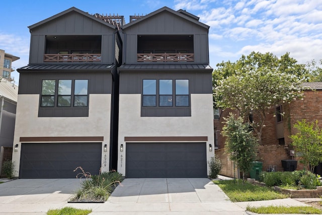 townhome / multi-family property with an attached garage, driveway, a standing seam roof, and metal roof