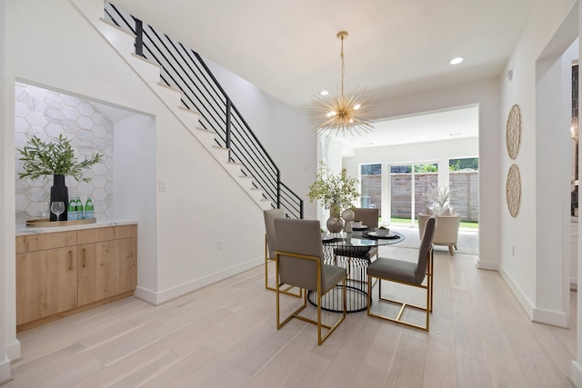 dining space featuring baseboards, a notable chandelier, light wood finished floors, and recessed lighting