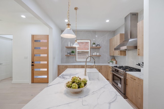 kitchen with light brown cabinetry, open shelves, wall chimney range hood, modern cabinets, and stainless steel range