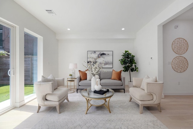 living area featuring baseboards, wood finished floors, visible vents, and recessed lighting