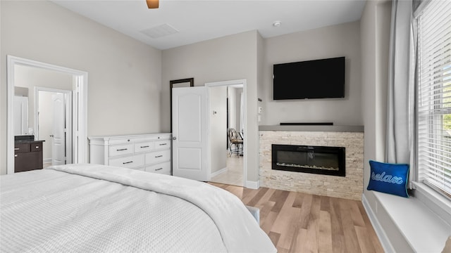119 Buckeye Dr, Montgomery, TX 77316 - bedroom with a ceiling fan, light wood-style flooring, baseboards, visible vents, and a fireplace