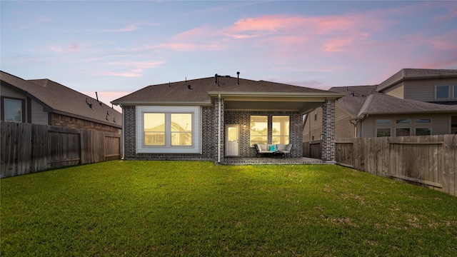 119 Buckeye Dr, Montgomery, TX 77316 - back of property featuring a yard, brick siding, and a fenced backyard
