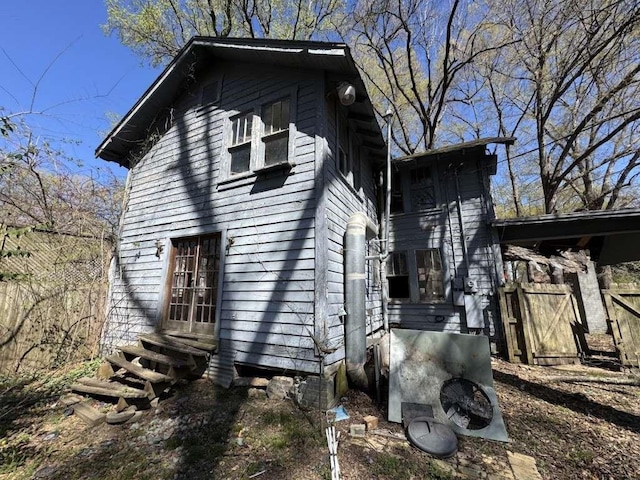 view of home's exterior with entry steps and fence