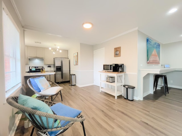 living room with visible vents, ornamental molding, light wood-type flooring, baseboards, and a notable chandelier