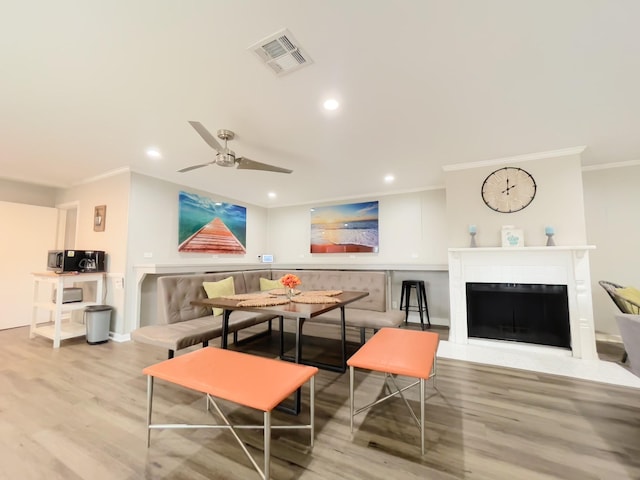 living room featuring recessed lighting, wood finished floors, visible vents, breakfast area, and ornamental molding