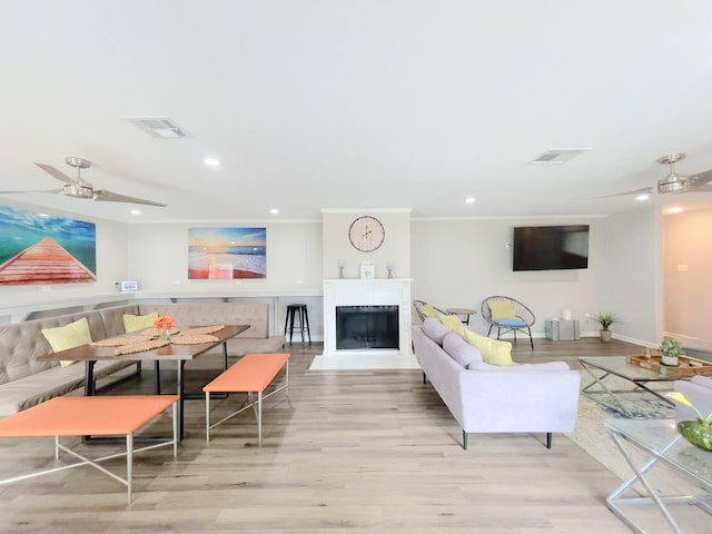 living room with wood finished floors, visible vents, and ceiling fan