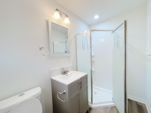 full bathroom with toilet, vanity, wood finished floors, and a stall shower