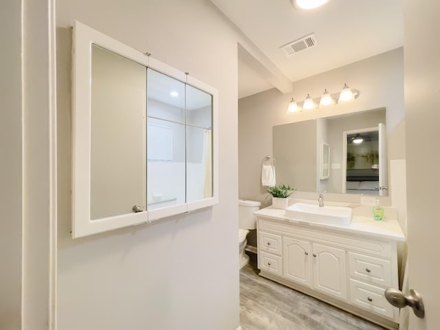 full bath with wood finished floors, visible vents, vanity, and toilet