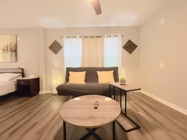 sitting room with baseboards, a ceiling fan, and wood finished floors