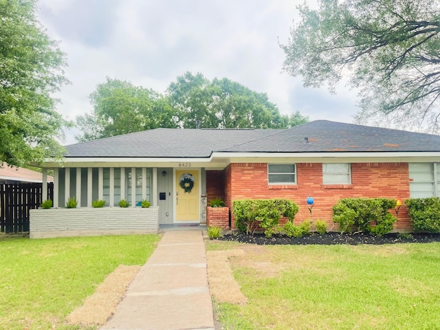 single story home featuring a shingled roof and a front lawn