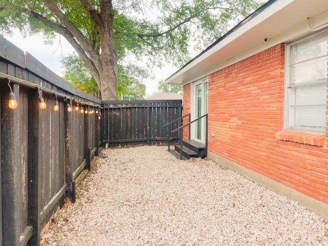 view of yard featuring entry steps and a fenced backyard