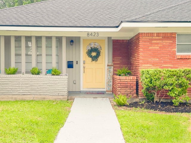 8423 Glen Valley Dr, Houston, TX 77061 - entrance to property with a shingled roof, board and batten siding, brick siding, and a lawn