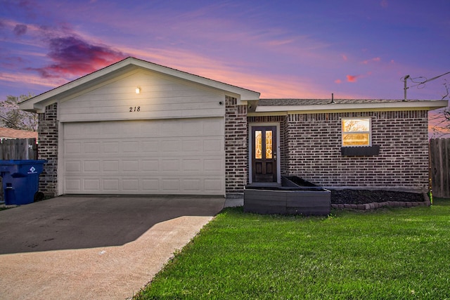 ranch-style house featuring driveway, fence, a garage, brick siding, and a lawn