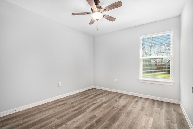 spare room featuring baseboards, a ceiling fan, and wood finished floors