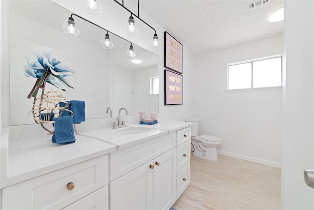 full bathroom with visible vents, toilet, vanity, baseboards, and a textured ceiling