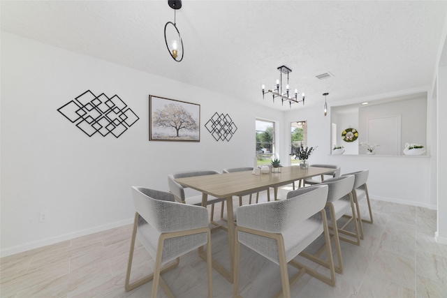 dining room with an inviting chandelier, a textured ceiling, visible vents, and baseboards