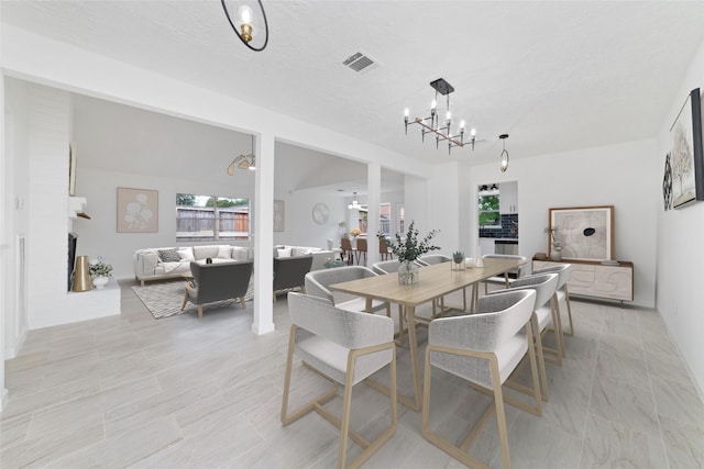 dining area featuring a textured ceiling, a chandelier, and visible vents