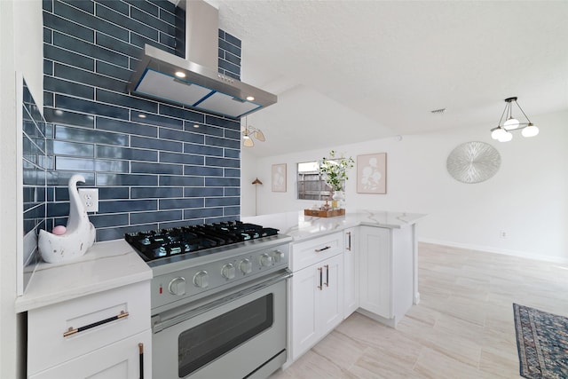 kitchen with range with gas stovetop, a peninsula, light stone counters, wall chimney range hood, and white cabinets