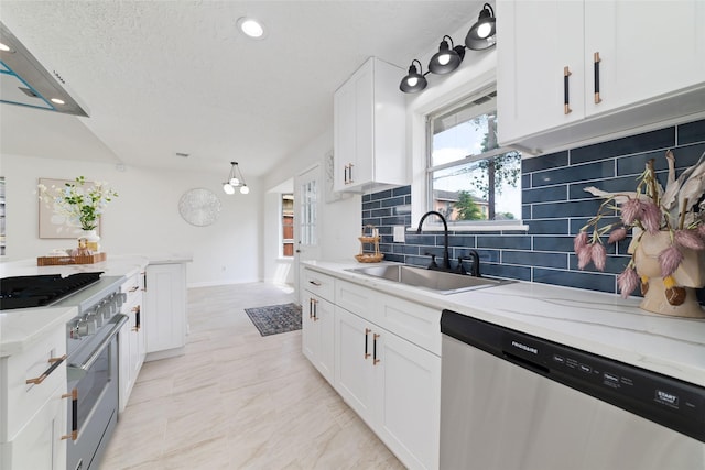 kitchen featuring decorative backsplash, appliances with stainless steel finishes, white cabinets, a sink, and baseboards