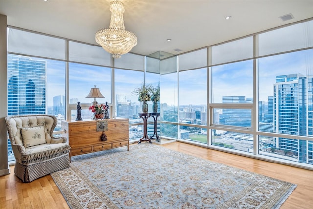 living area with a chandelier, floor to ceiling windows, and a wealth of natural light