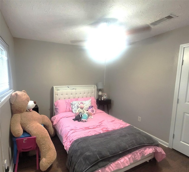bedroom with a textured ceiling and visible vents
