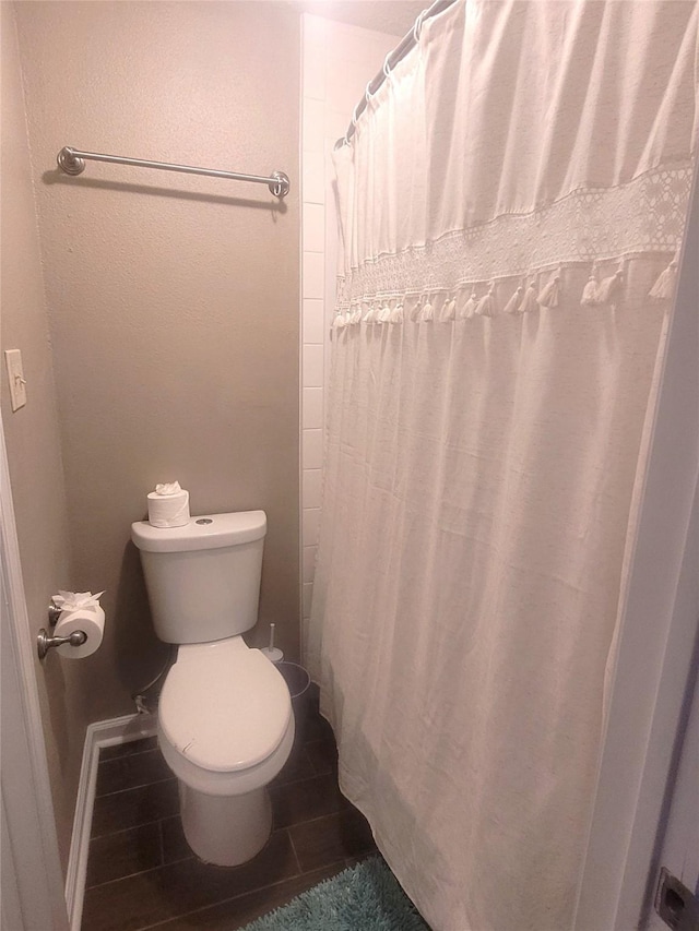 full bathroom with toilet and a shower with curtain