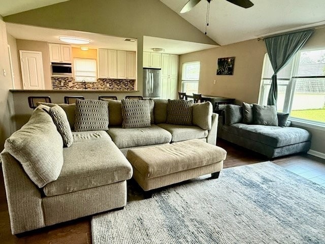 living room with a ceiling fan, vaulted ceiling, and a wealth of natural light