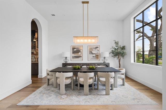 216 W 31st St, Houston, TX 77018 - dining space featuring arched walkways, baseboards, plenty of natural light, and wood finished floors