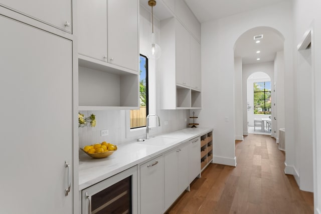 216 W 31st St, Houston, TX 77018 - bar area with a sink, beverage cooler, arched walkways, light wood-style floors, and decorative backsplash