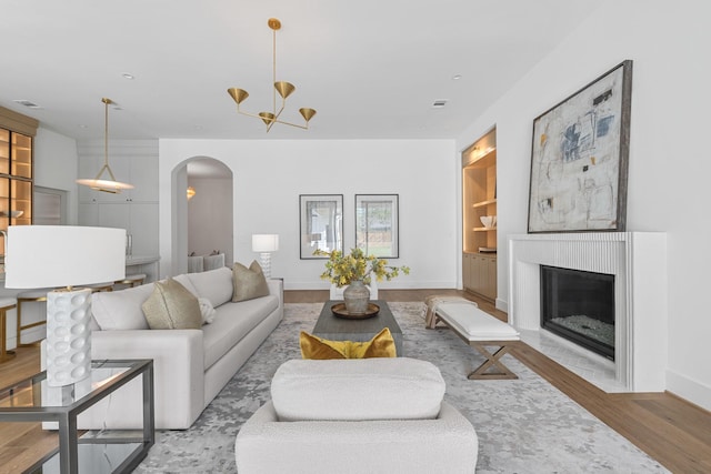 216 W 31st St, Houston, TX 77018 - living room with arched walkways, baseboards, a chandelier, wood finished floors, and a fireplace