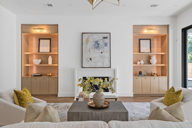 216 W 31st St, Houston, TX 77018 - living area with light wood-type flooring, built in shelves, and baseboards