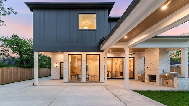 216 W 31st St, Houston, TX 77018 - back of house at dusk with area for grilling, a patio, fence, and board and batten siding