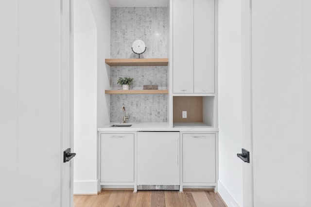 216 W 31st St, Houston, TX 77018 - indoor wet bar featuring decorative backsplash, dishwashing machine, light wood-style flooring, and baseboards