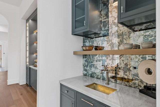 216 W 31st St, Houston, TX 77018 - indoor wet bar featuring backsplash, light wood-style flooring, arched walkways, and baseboards