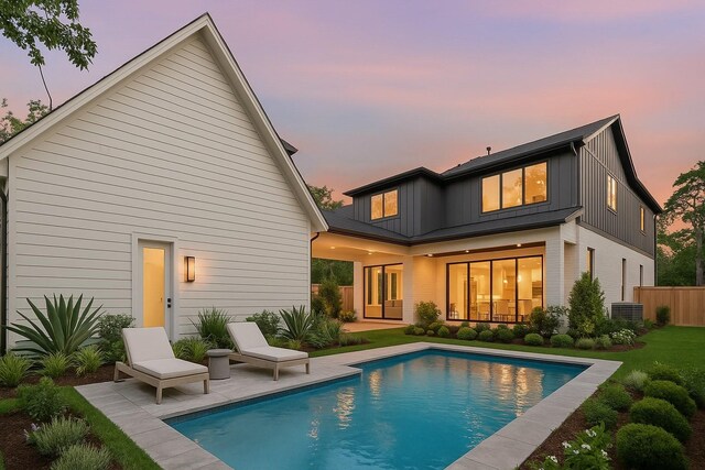 216 W 31st St, Houston, TX 77018 - back of property at dusk featuring board and batten siding, a patio, central AC unit, an outdoor pool, and fence